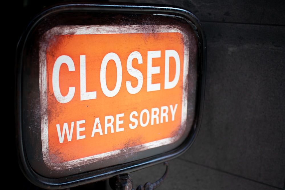 a close up of a closed sign on a pole