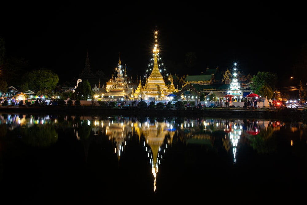 a night scene of a large building with a reflection in the water