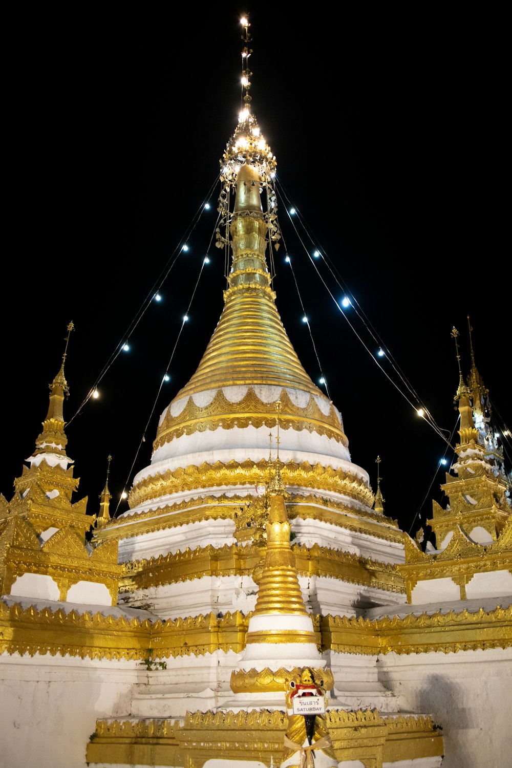 a large golden and white building with lights on it