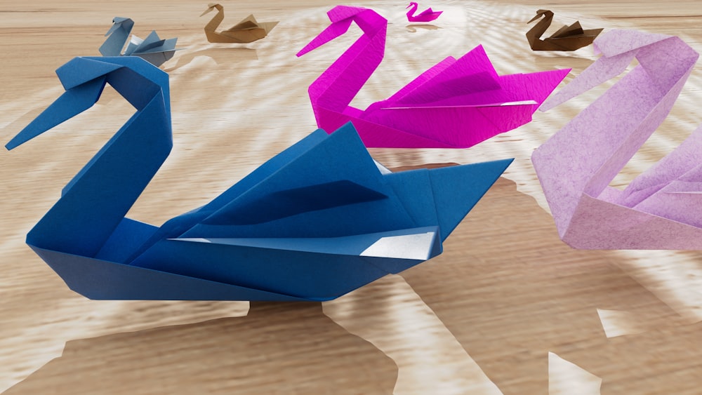 three origami swans on a wooden surface