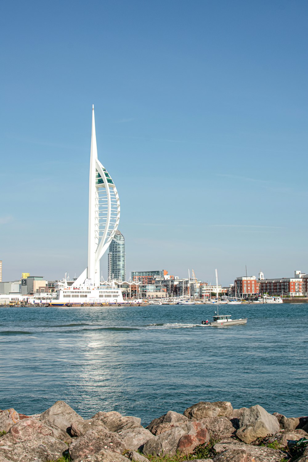 a sailboat in a body of water with a city in the background