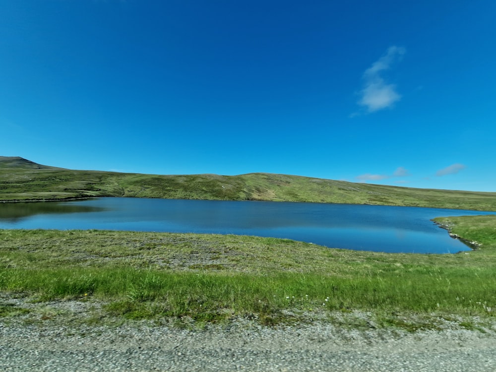 a large body of water surrounded by a lush green hillside