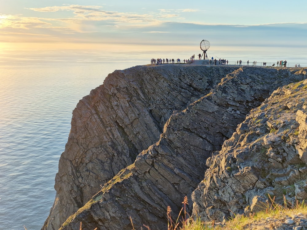 a group of people standing on top of a cliff