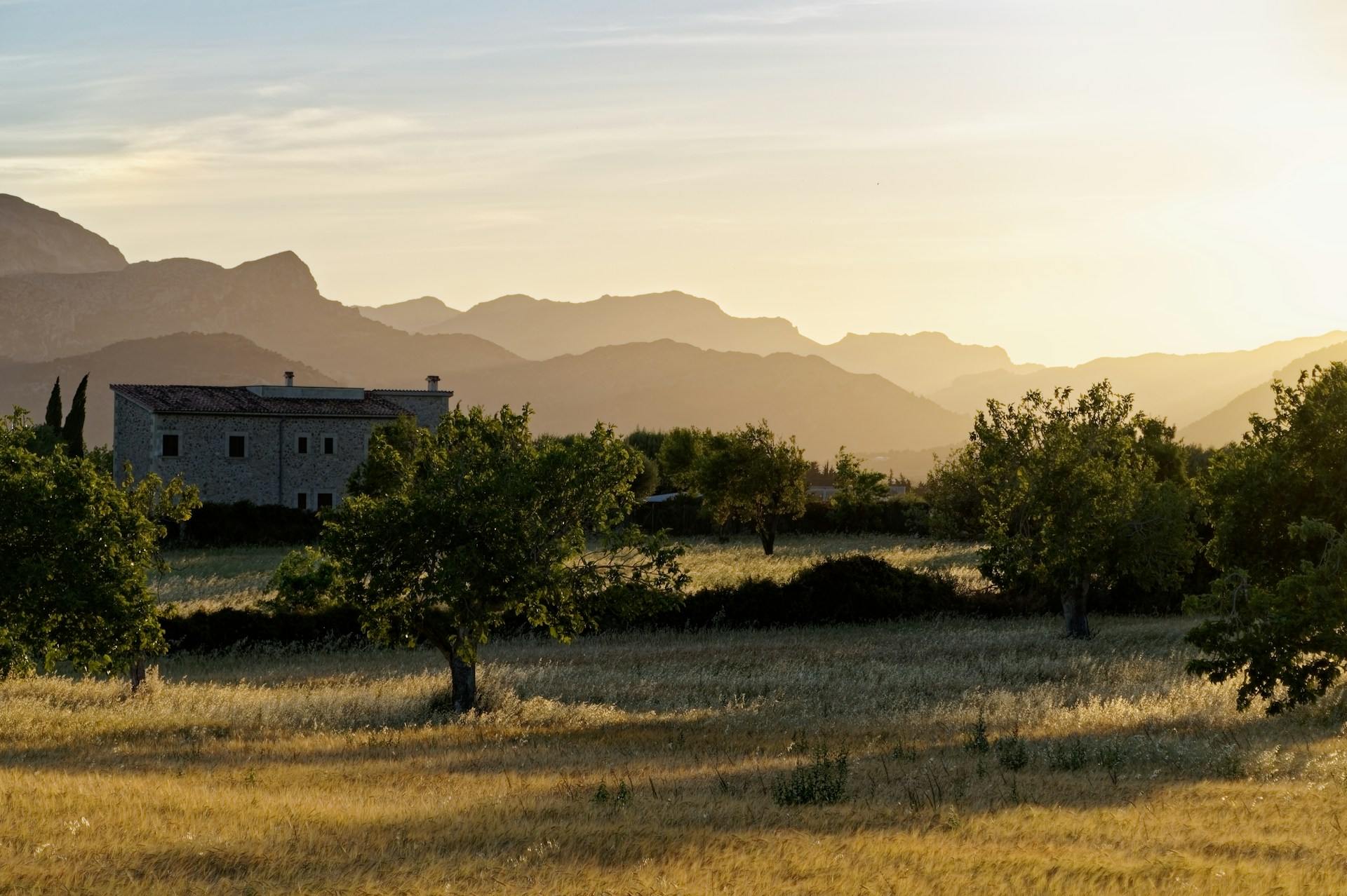 a house in a field with mountains in the background