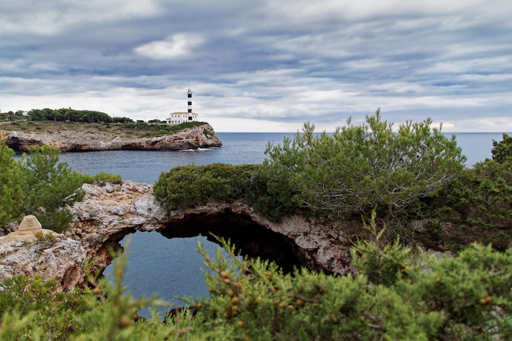 a lighthouse on a small island in the middle of the ocean