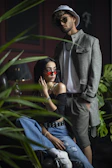 Stylish couple sharing a candid moment in an upscale lounge setting, wearing Lumina Apparel pieces.