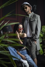 A stylish couple wearing modern outfits in a minimalist urban setting.