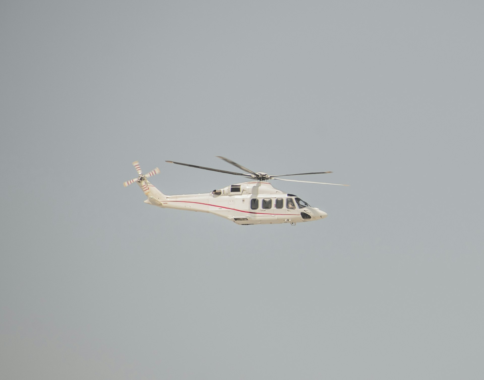 a helicopter flying in the air with a sky background