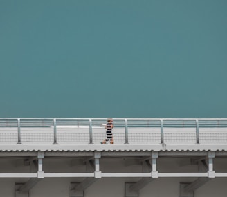 A serene morning jogger wearing teal-accented minimalist activewear from zentic against a soft cream background.