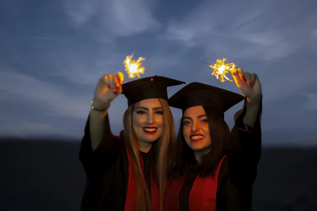 Graduation ceremony with joyful students in caps and gowns celebrating their achievement.