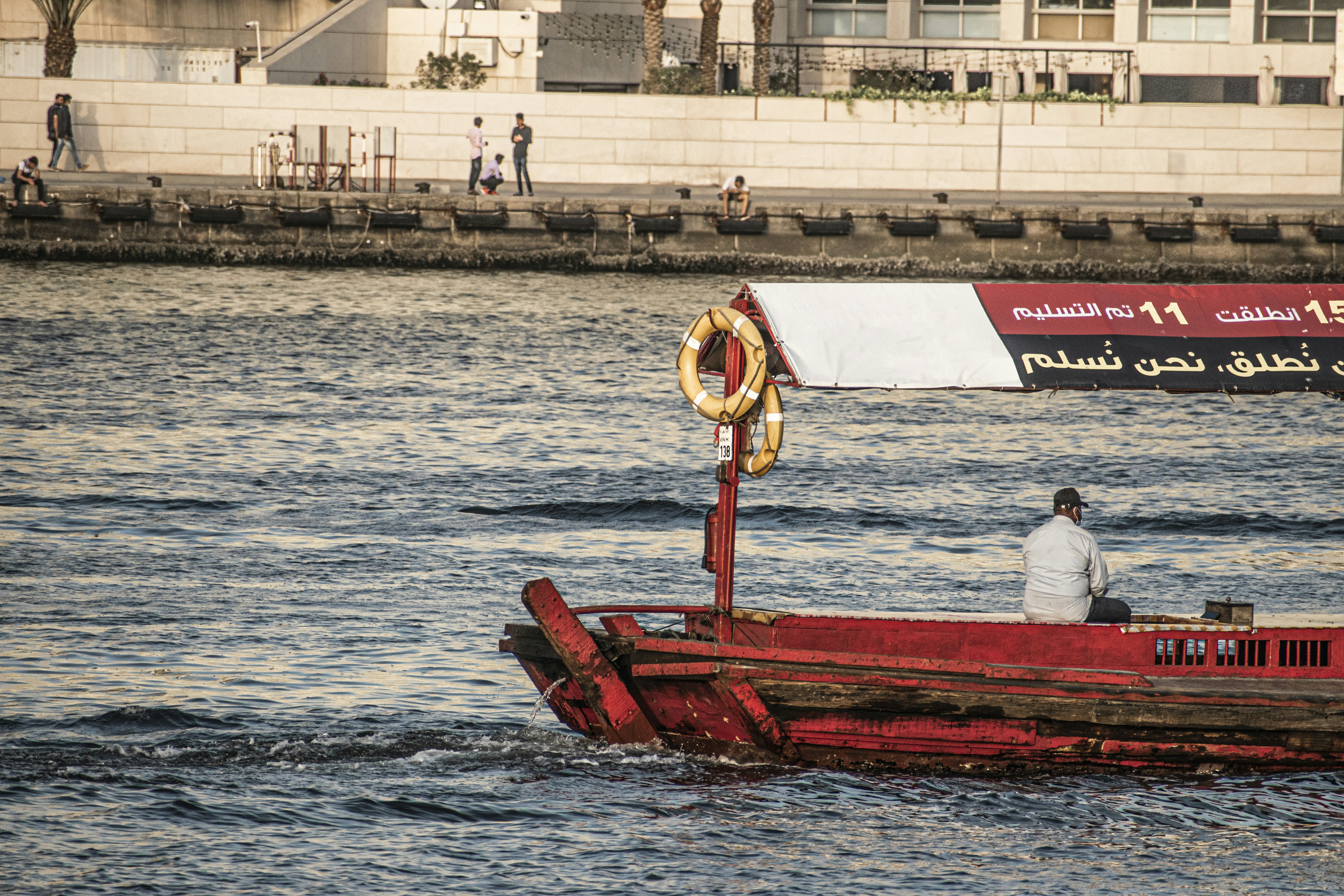 a man sitting in a red boat in the water