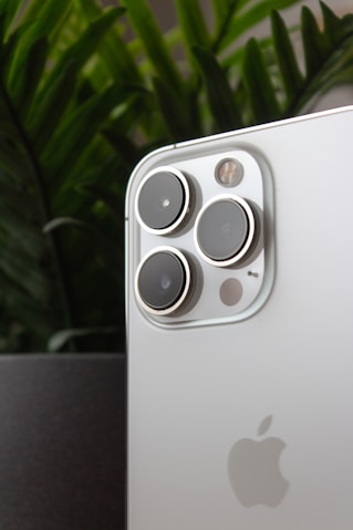 a close up of a cell phone with a plant in the background