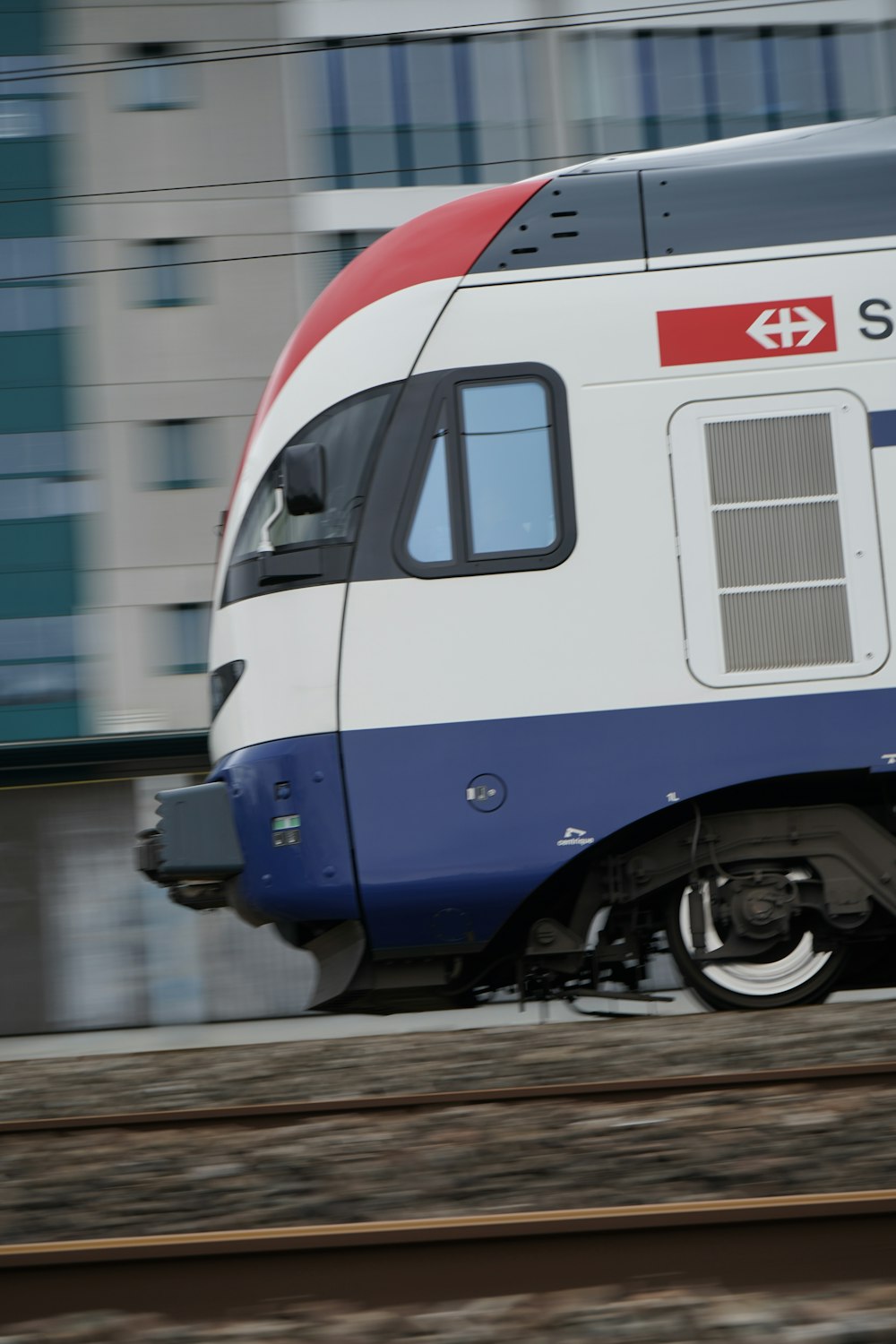 a white and blue train traveling down train tracks