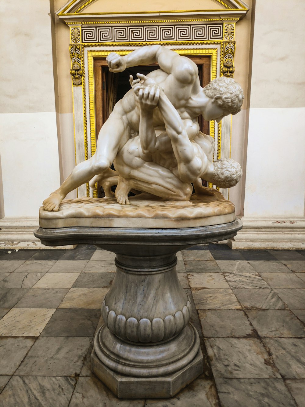 a statue of two men wrestling in a room