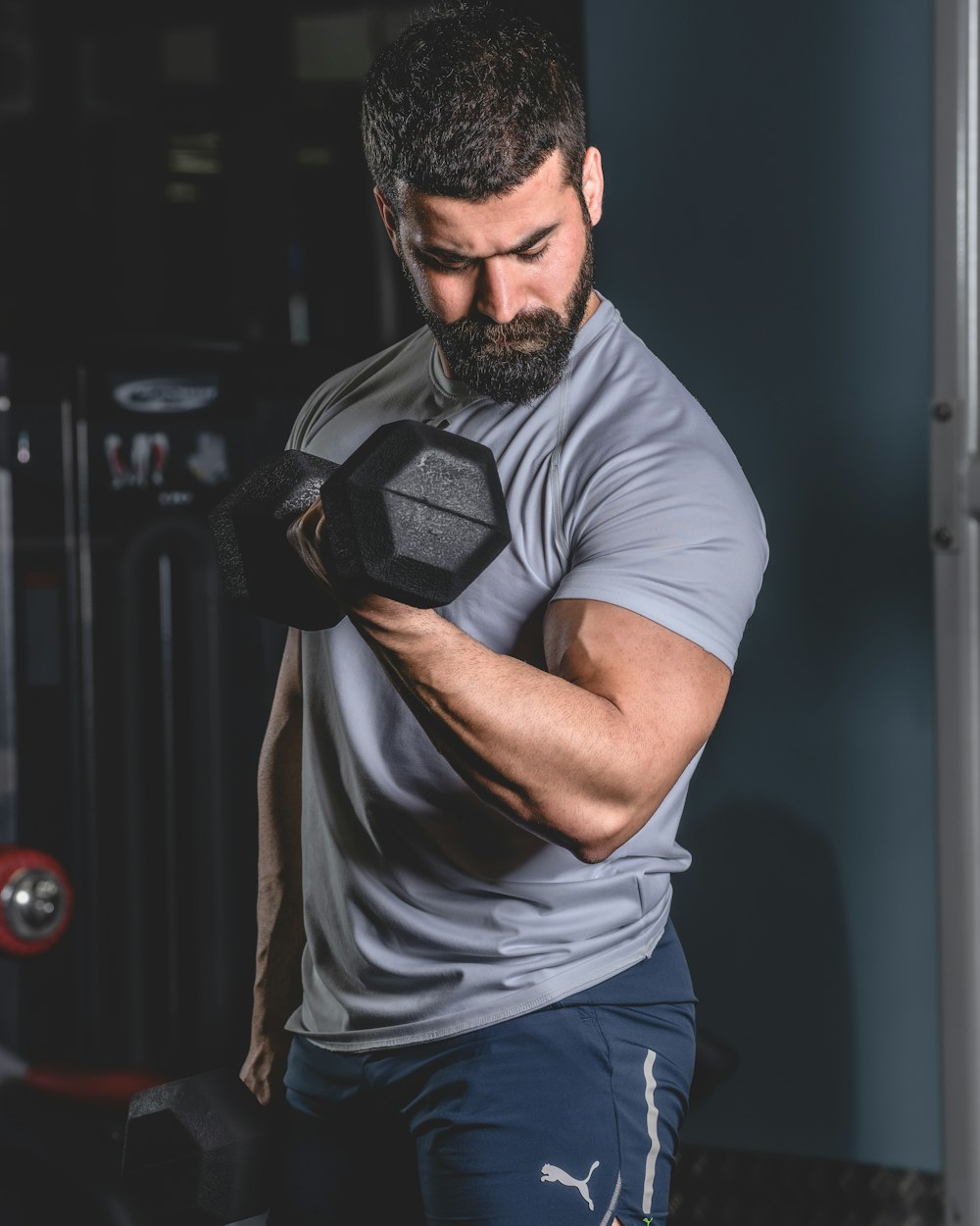 a man with a beard is holding a dumbbell