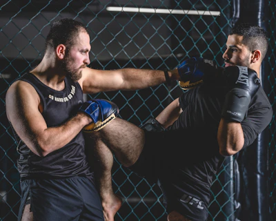 A close-up of two students sparring with escrima sticks, focused and intense.
