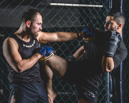 A dynamic MMA training session showing close combat and intense focus between two athletes.