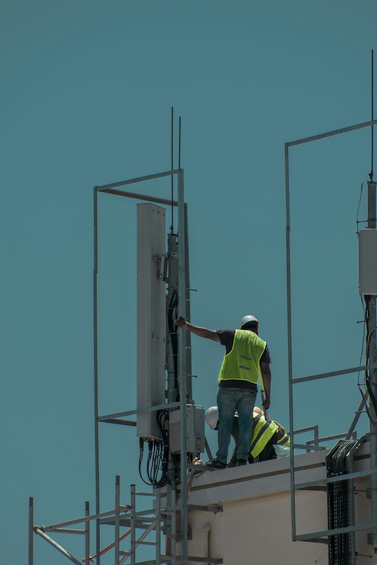 A single person working on a cell tower — one person maintaining infrastructure that serves millions