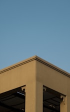 Minimalist residential building with warm neutral tones and clean lines under soft natural light.