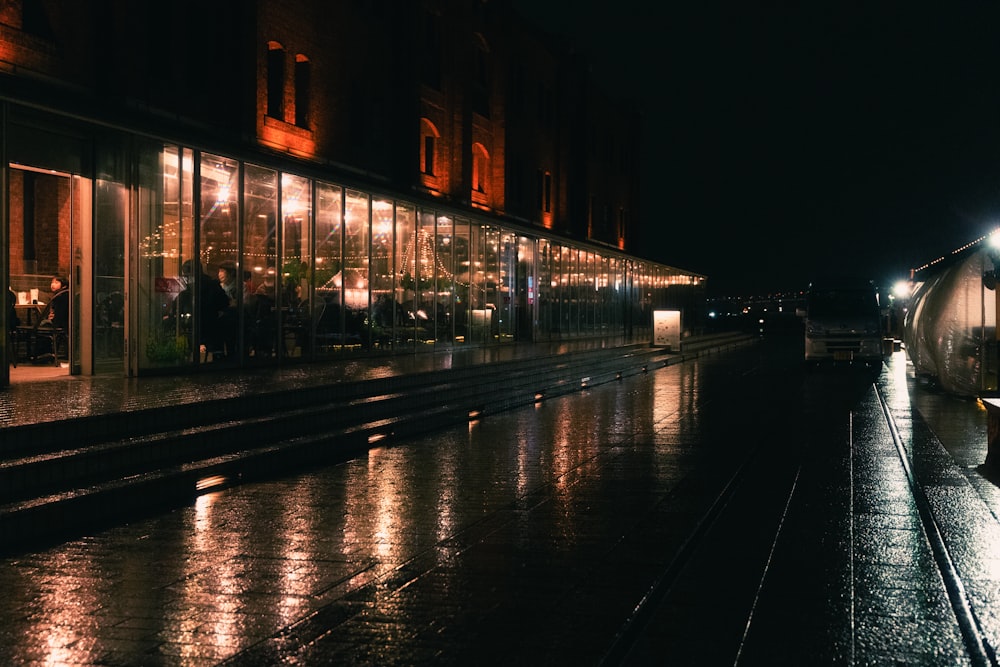 Eine Stadtstraße bei Nacht mit einem Zug auf den Gleisen