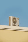 a white air conditioner sitting on top of a building