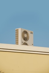 a white air conditioner sitting on top of a building