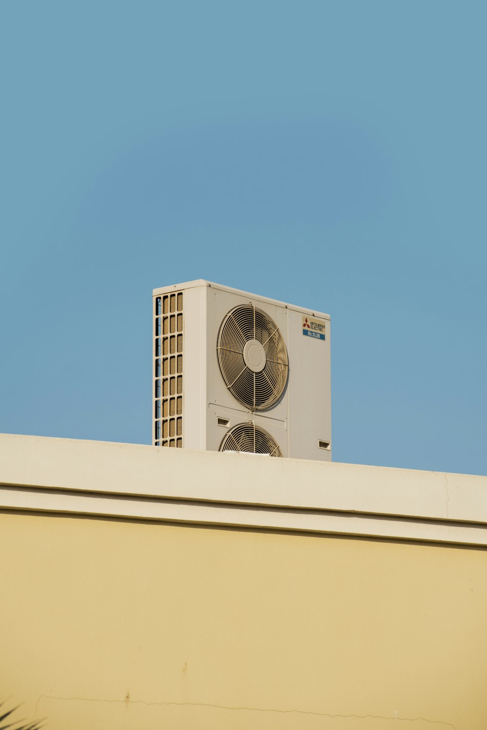 a white air conditioner sitting on top of a building