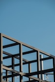 Minimalist construction site with steel framework against a clear sky.