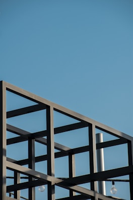 Minimalist construction site with steel framework against a clear sky.