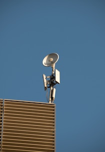 Close-up of a modern TV antenna connected to a building exterior with cables neatly arranged.