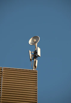 A modern home with a satellite dish on the roof receiving internet signal.