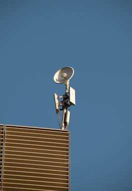 A modern, sleek satellite dish installation against a clear blue sky in Riyadh.