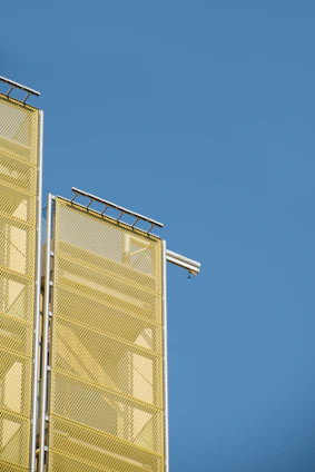 Modern CCTV cameras installed on a building exterior under clear blue sky