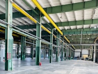 Bright and clean factory floor with steel beams and equipment in preparation.