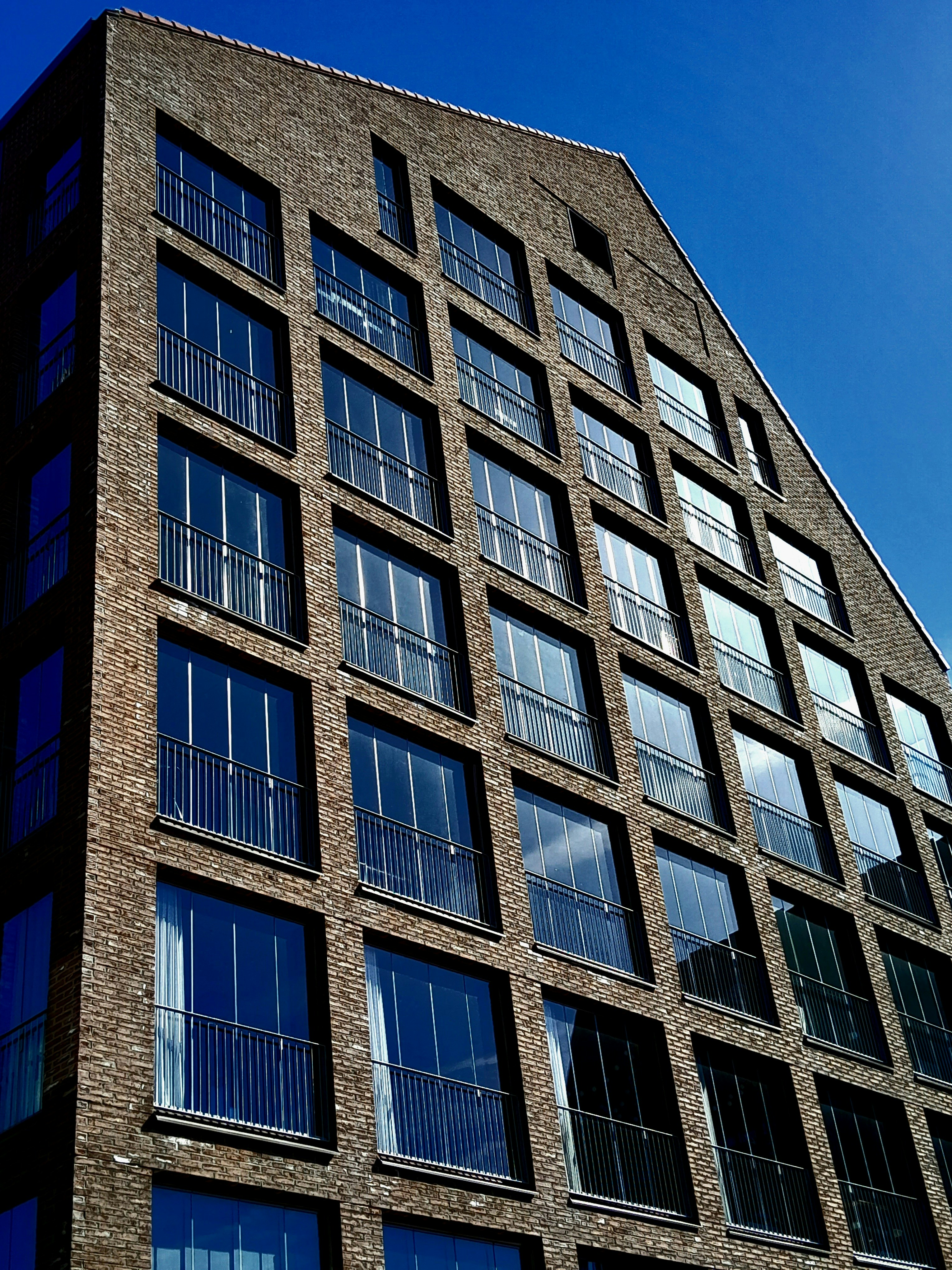 A very tall brick building with lots of windows photo – Free City Image ...