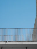 Minimalist aluminum balcony railing with a cityscape background at sunset.
