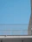 Minimalist aluminum balcony railing with a cityscape in the background during sunset.