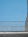 Minimalist aluminum balcony railing with a cityscape in the background during sunset.