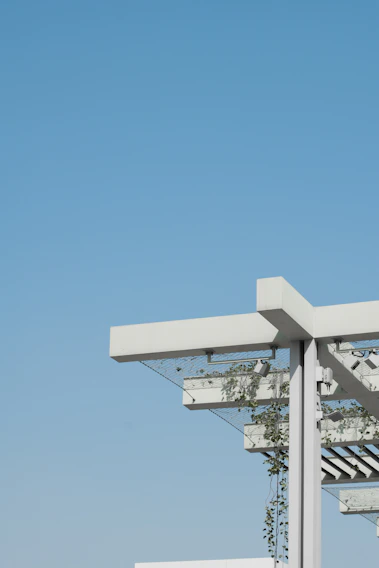 Close-up of a sturdy steel pergola frame under a bright sky, showcasing precise welding and clean lines.