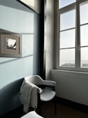 A cozy winter jacket draped over a chair near a window with soft light.