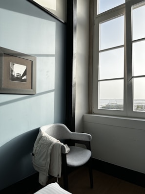 A cozy winter jacket draped over a chair near a window with soft light.