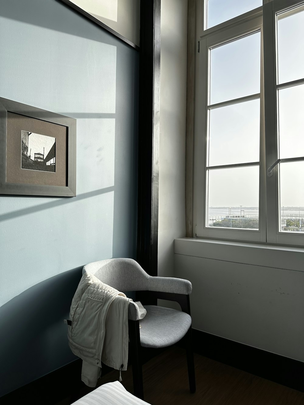 a white chair sitting in a room next to a window