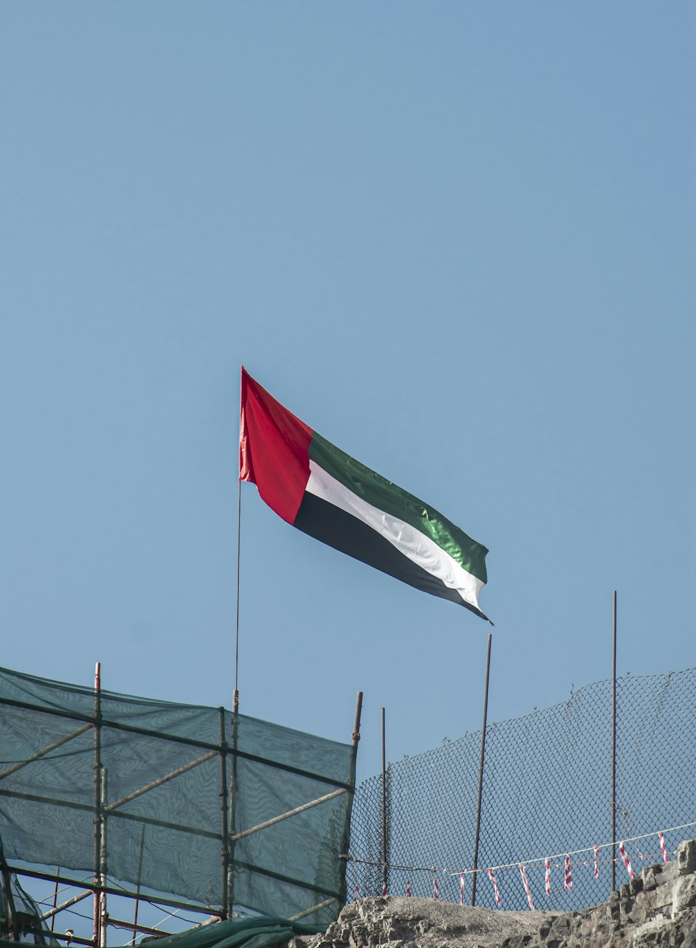 the flag of the united states of jordan flying over a fence