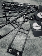 Military-style dog tags with crisp engraved text and designs displayed on a rustic wooden table