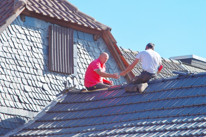 Roofers installing underlayment during a roof replacement