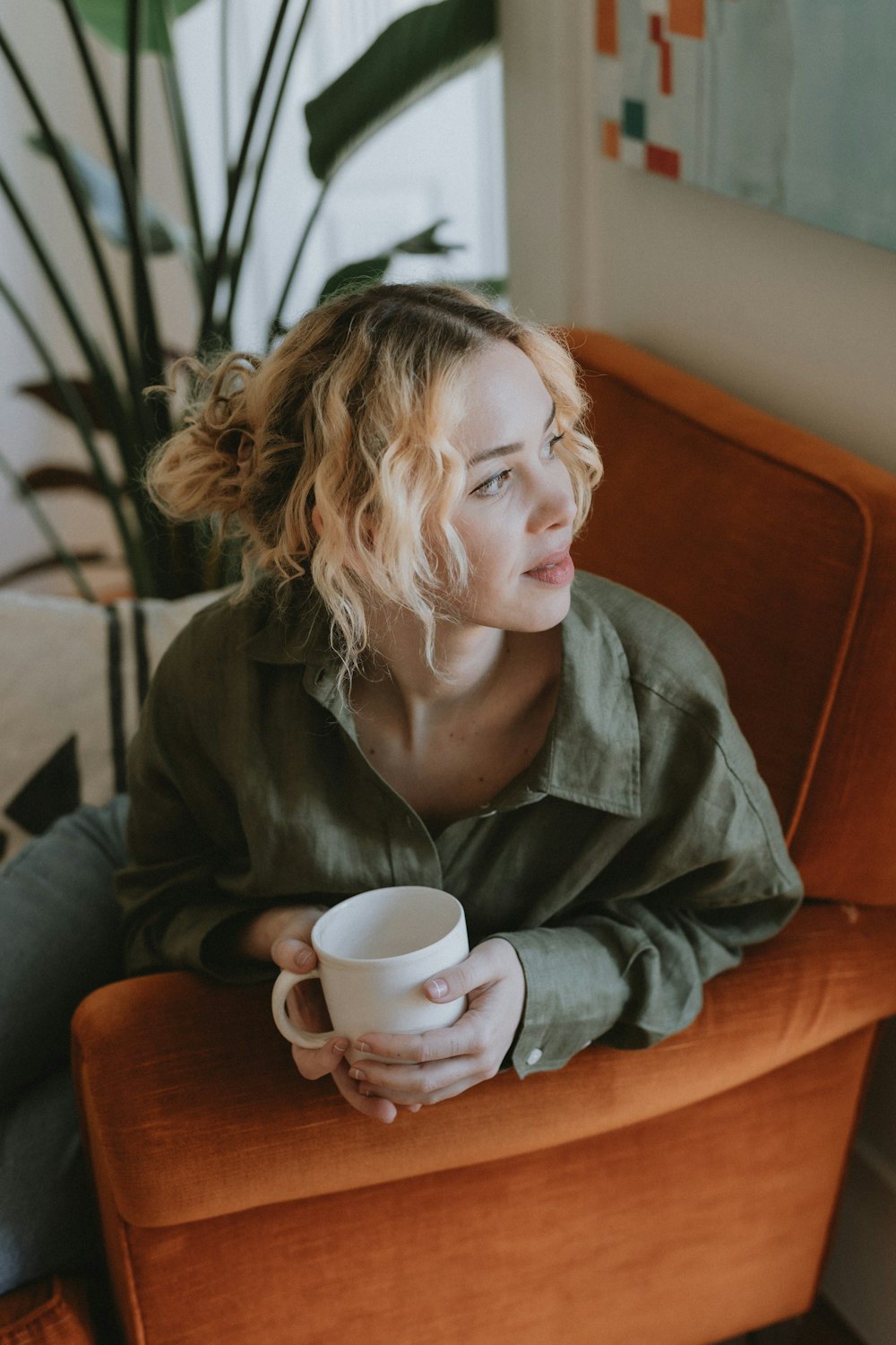 a woman sitting in a chair holding a cup