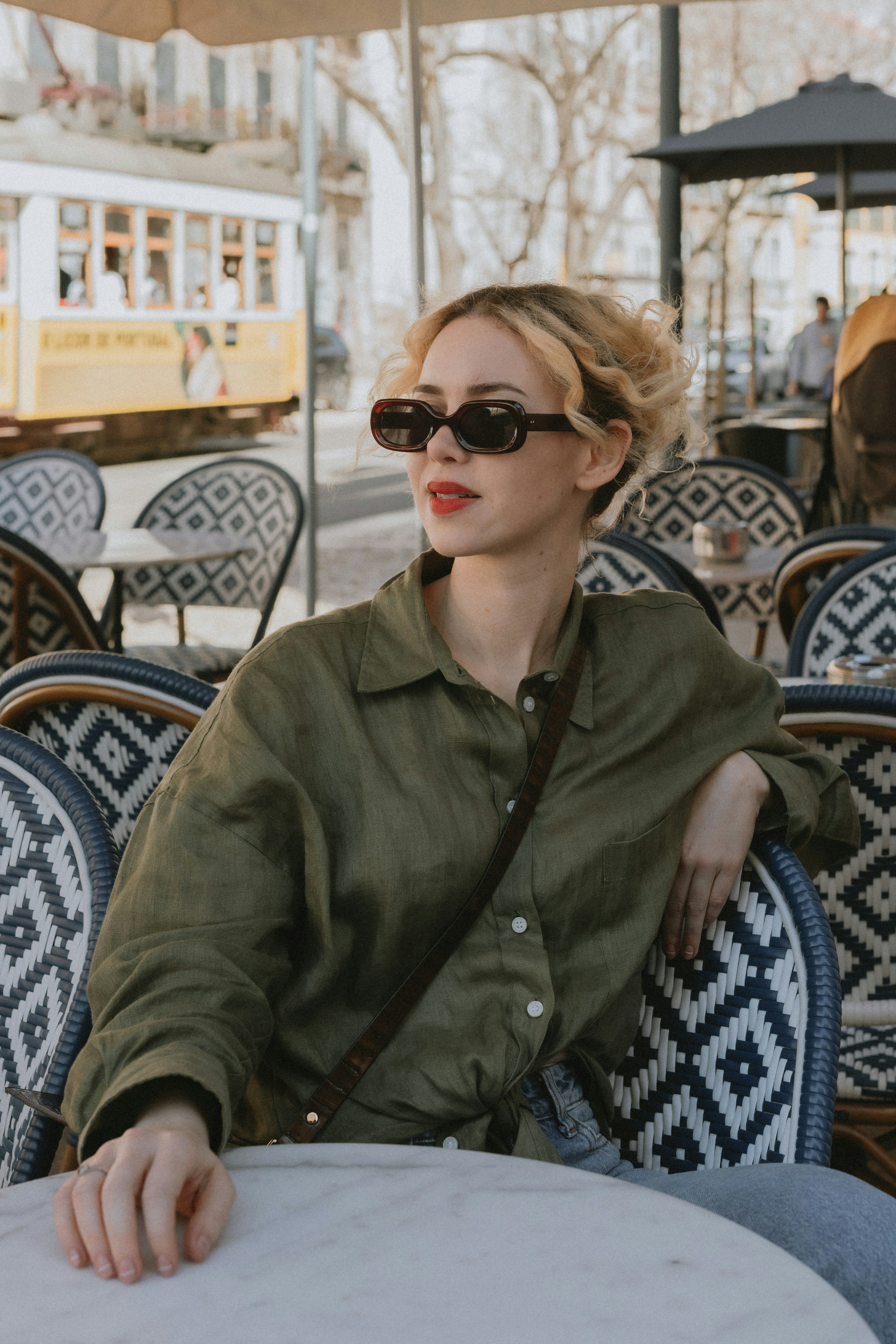 a woman sitting at a table with an umbrella over her head