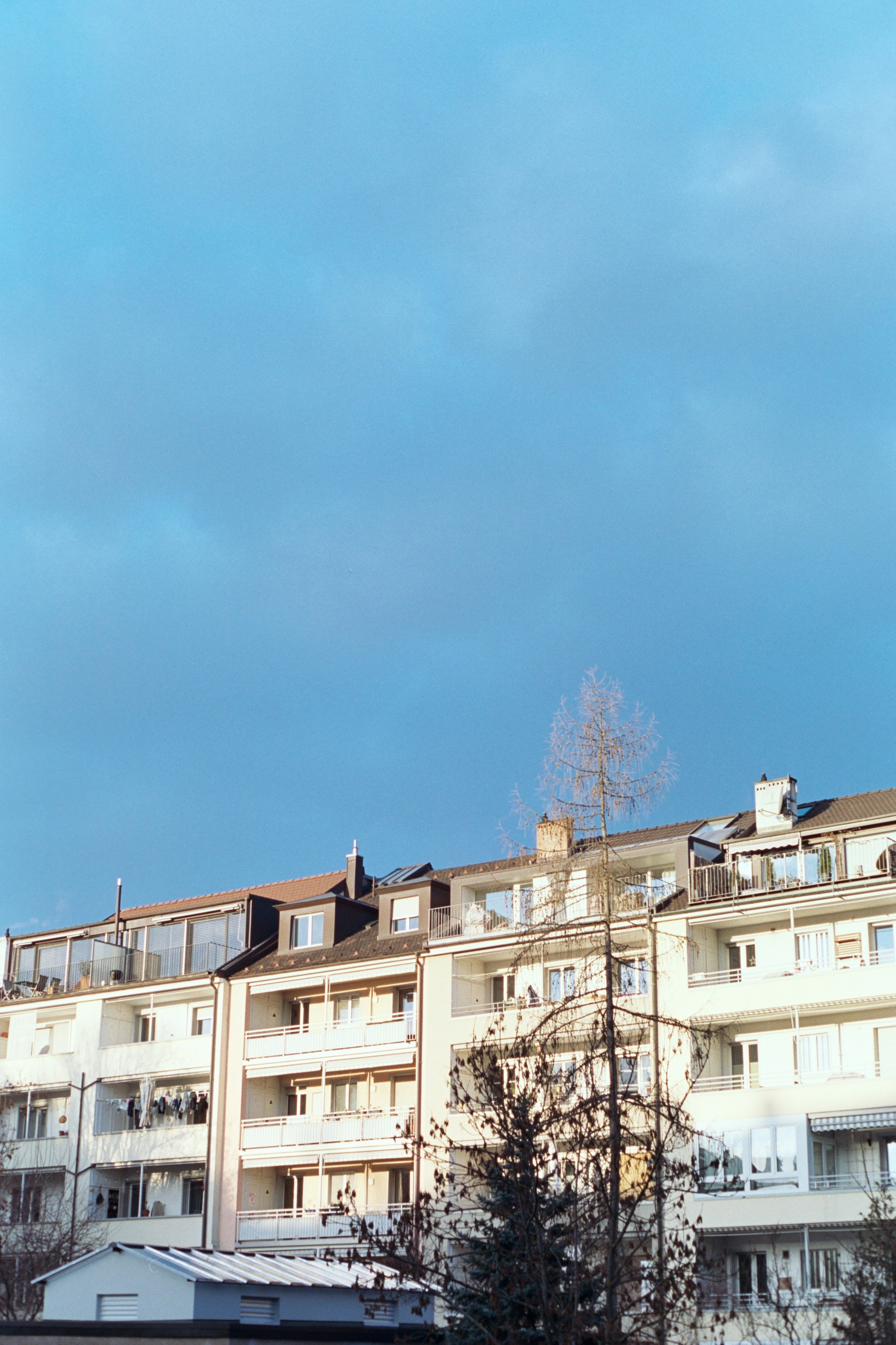 a clock tower in front of a row of apartment buildings