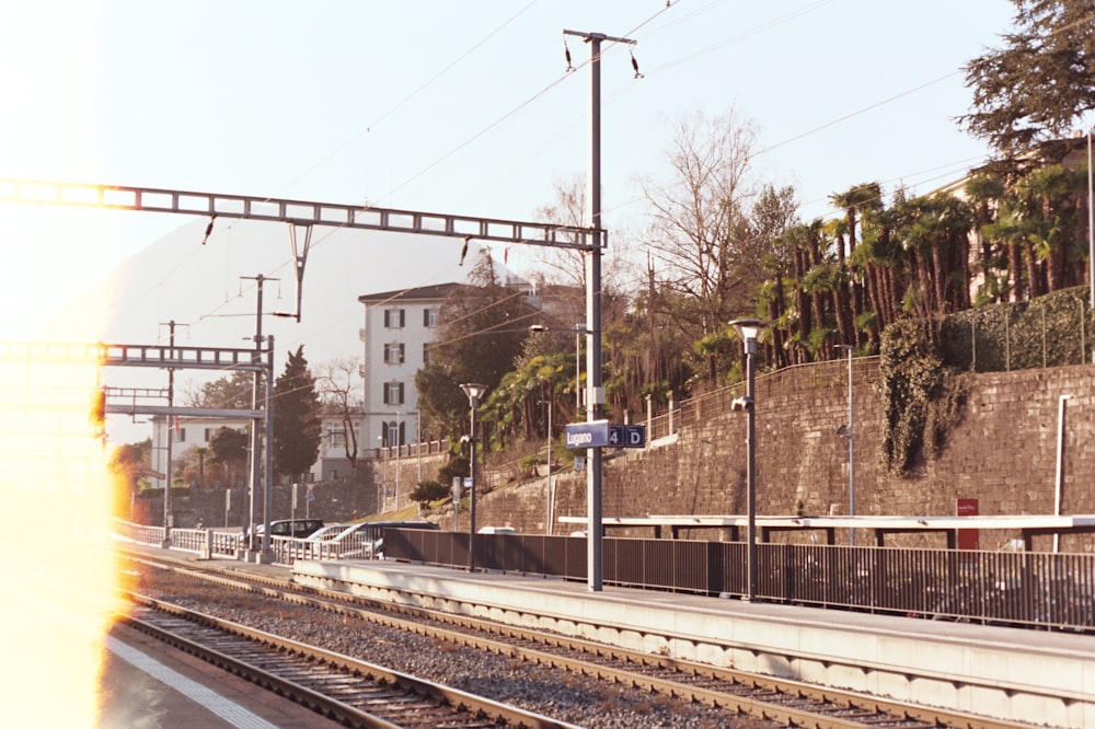 a train traveling down train tracks next to a tall building