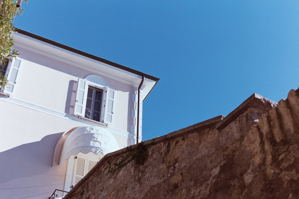 a white building with shutters on the side of it